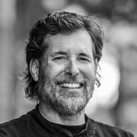 Ron Kenoyer, smiling, in a black and white portrait